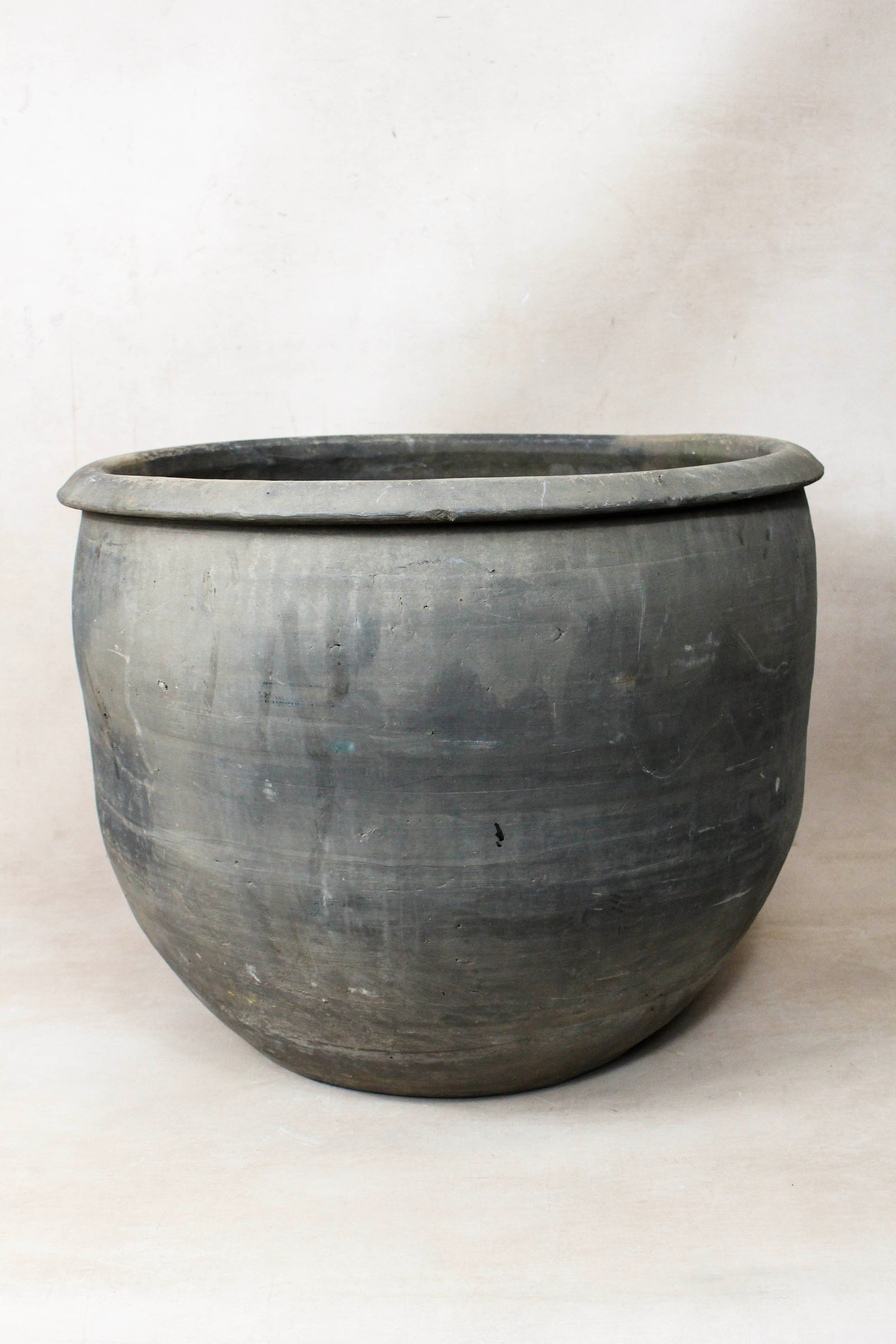 Large vintage dark clay pot — side view showing the aged patina