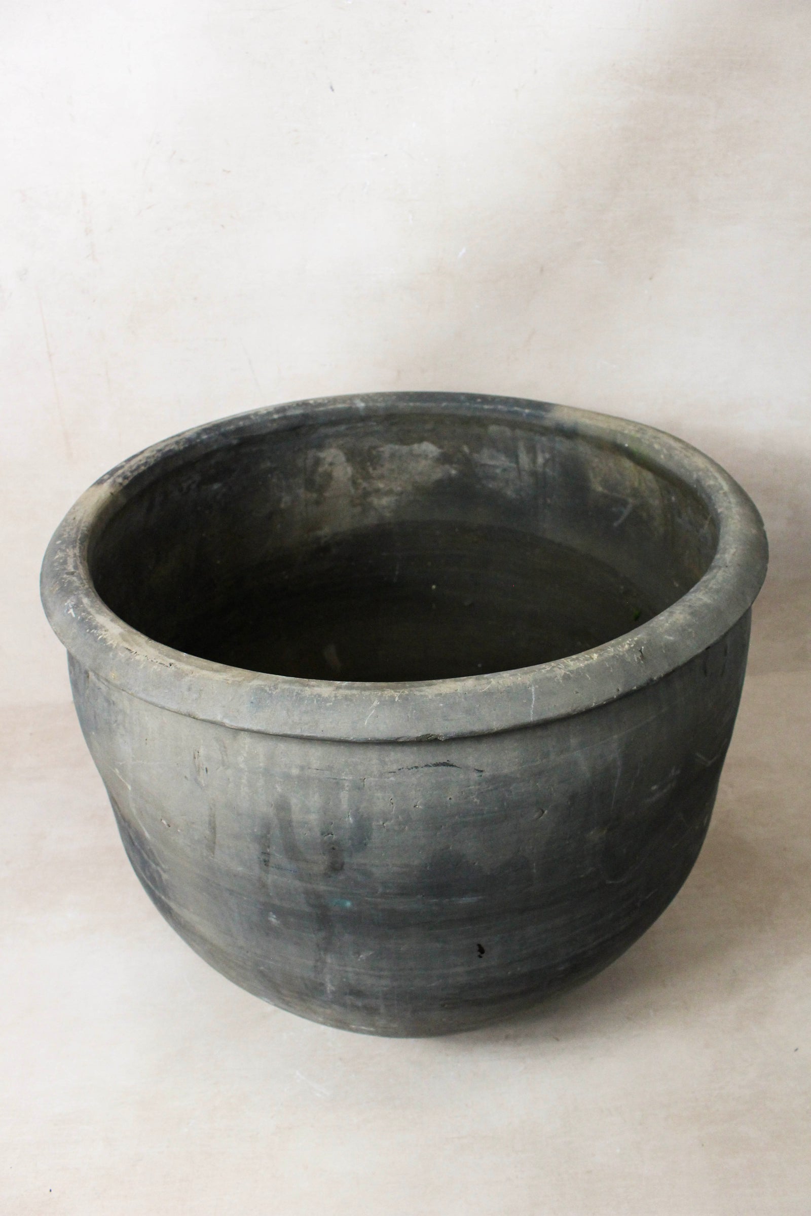 Large vintage dark clay pot — detail of the fired surface