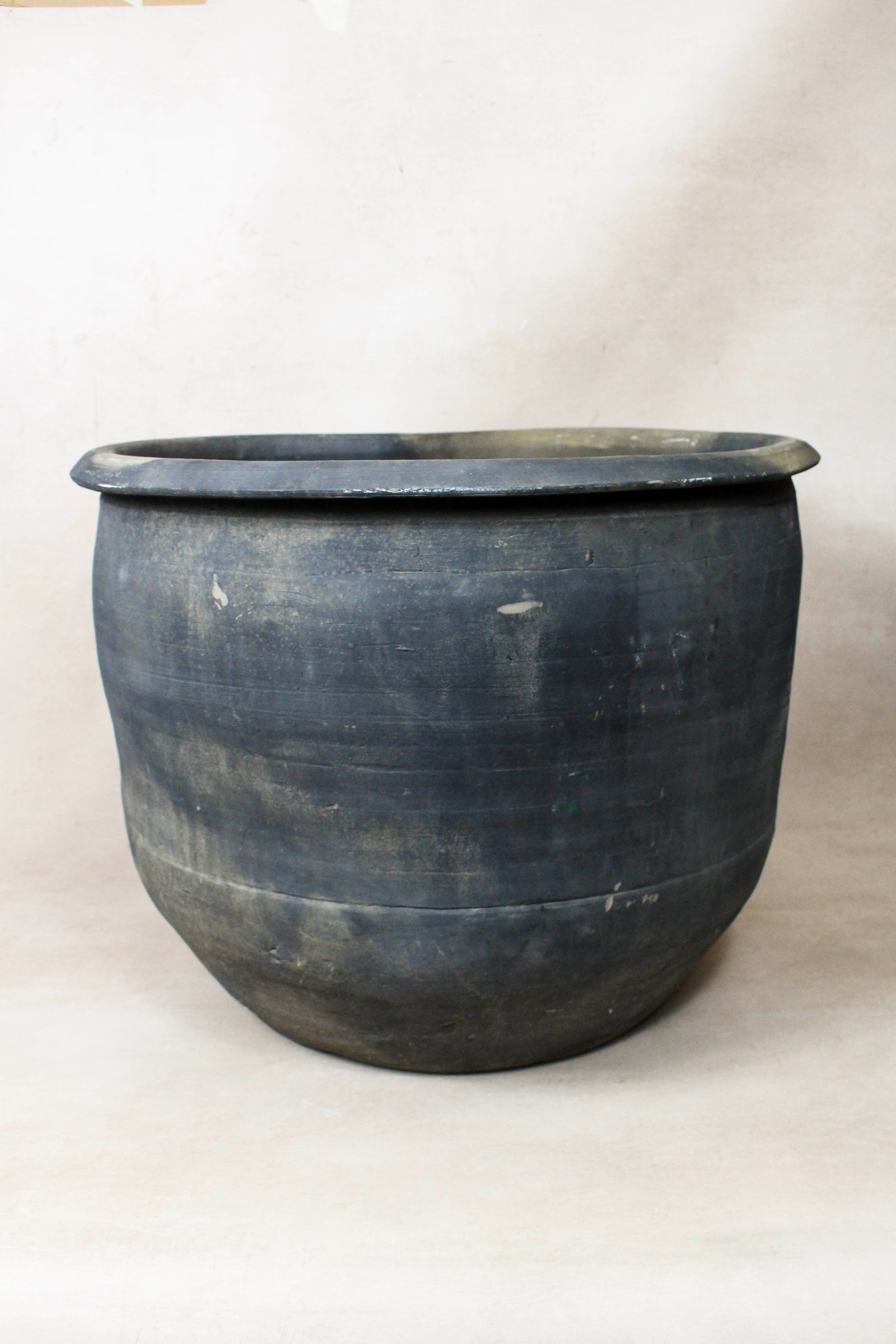 Large vintage dark clay pot — side view showing the aged patina