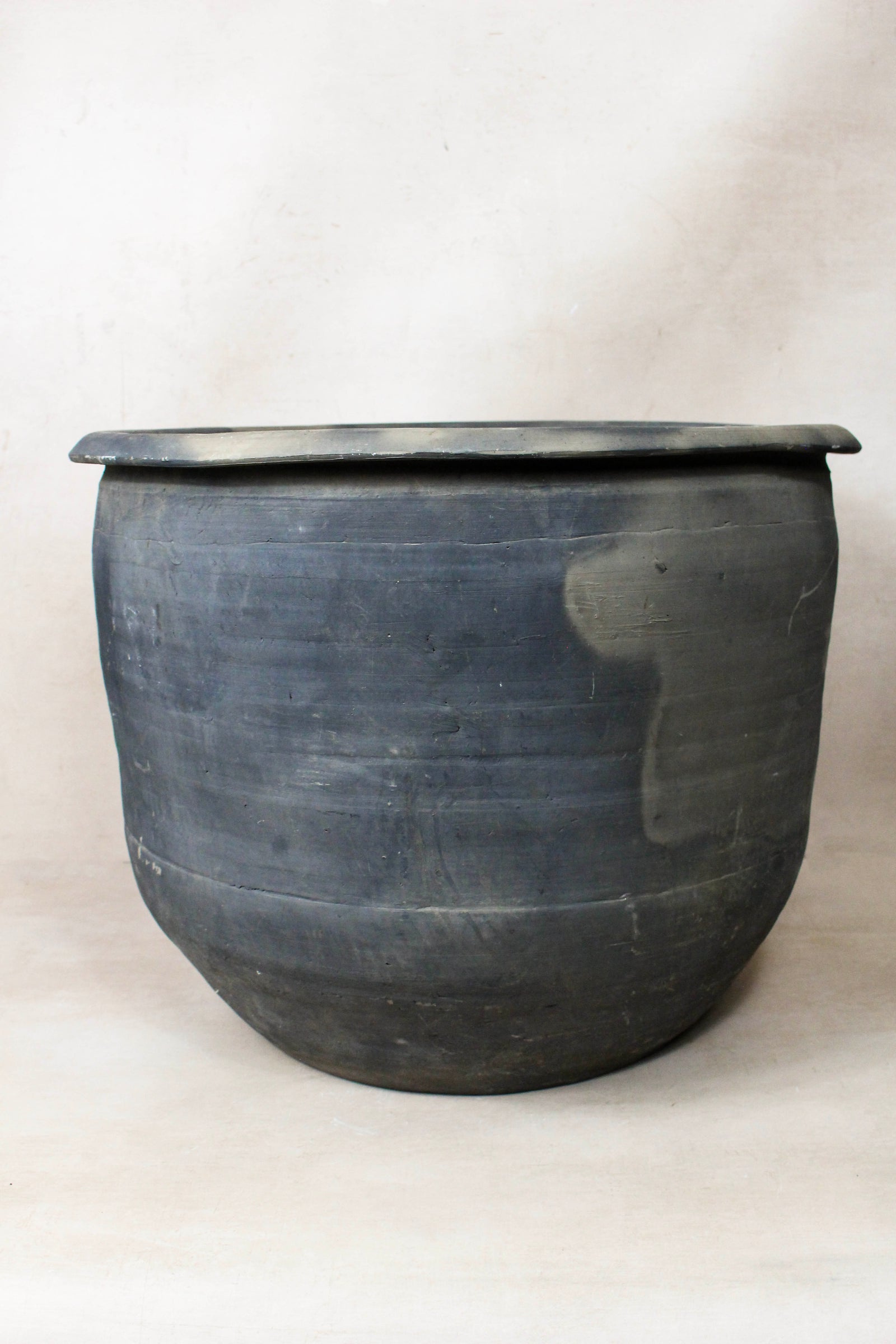 Large vintage dark clay pot — detail of the fired surface