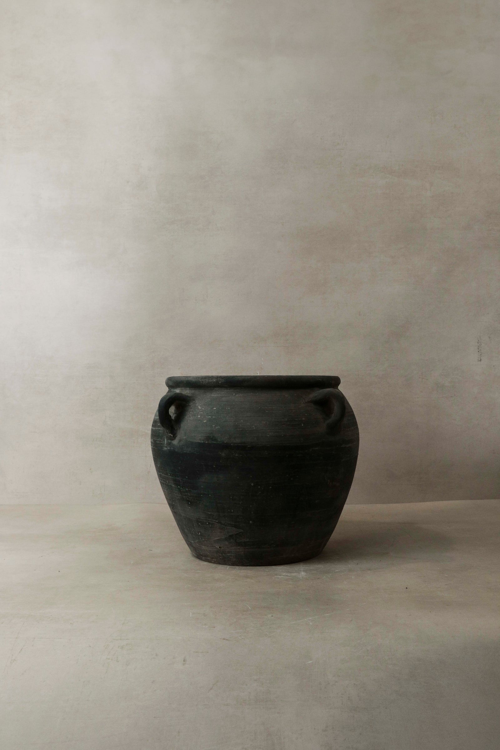Vintage dark pot with ears — side view showing the smoke-fired patina