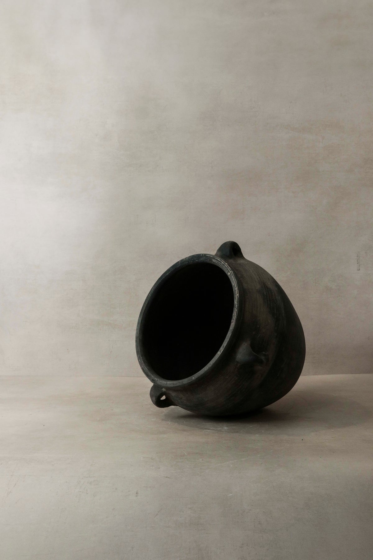 Vintage dark pot with ears — detail of a decorated ear handle