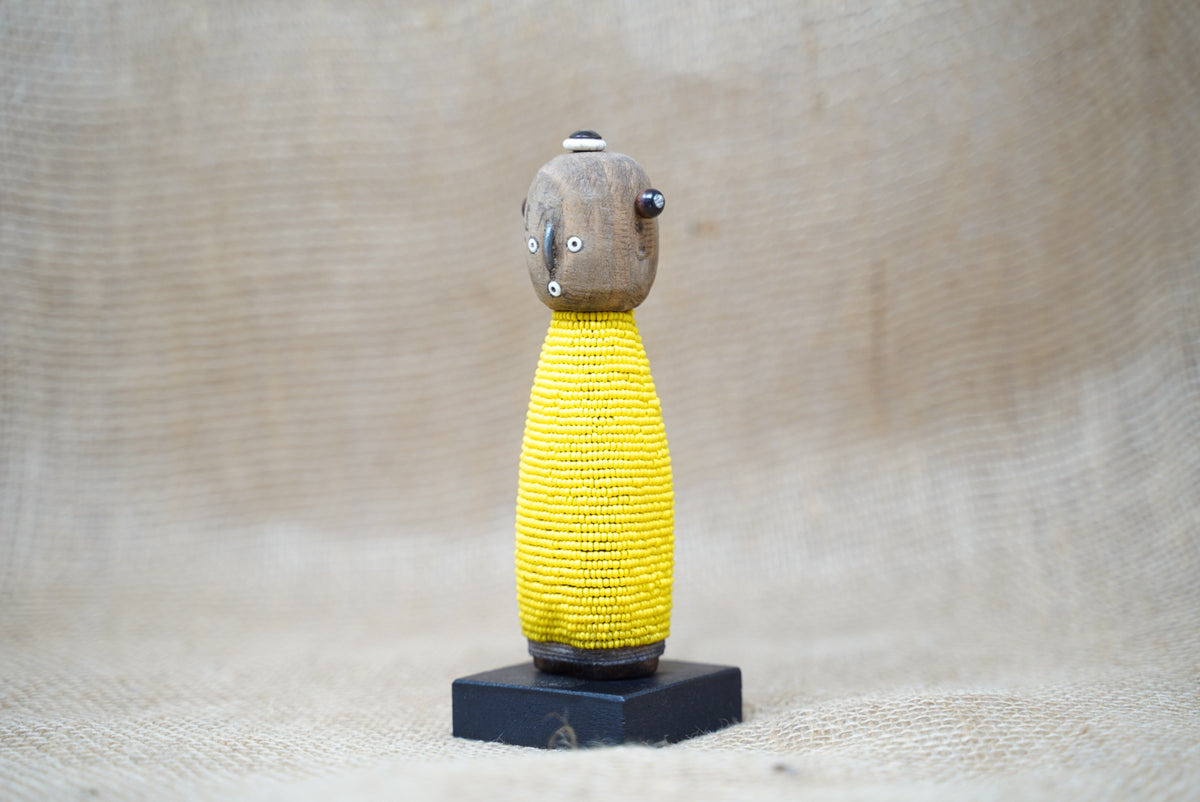 Yellow Namji baby doll, Cameroon — front view