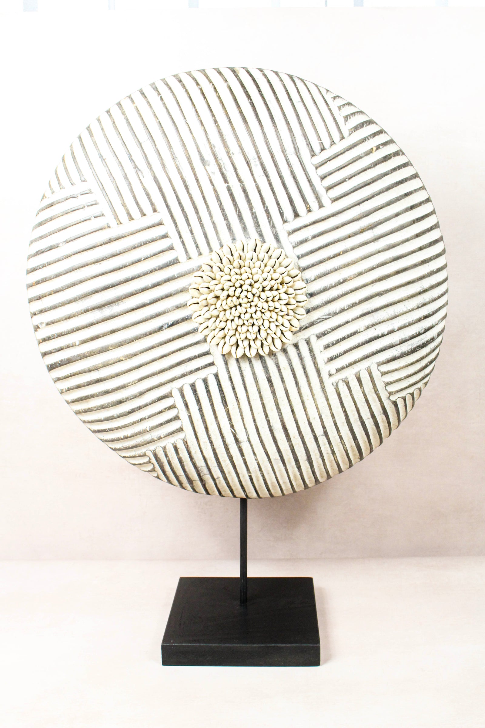 Cameroon Bamun round shield in blackened wood and white kaolin clay, on a steel stand