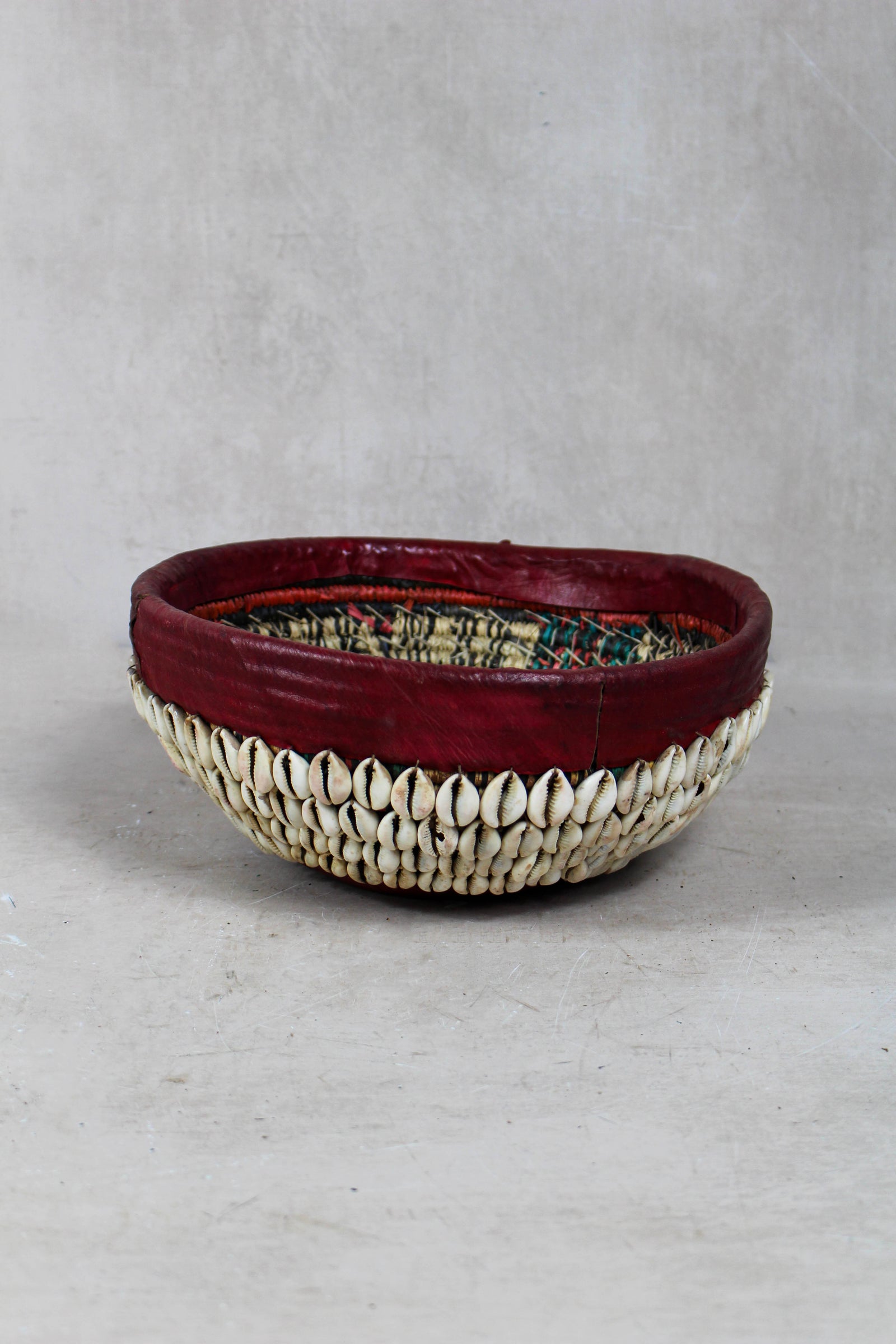 Vintage Hausa cowrie shell bowl from Northern Nigeria, woven grass with leather rim