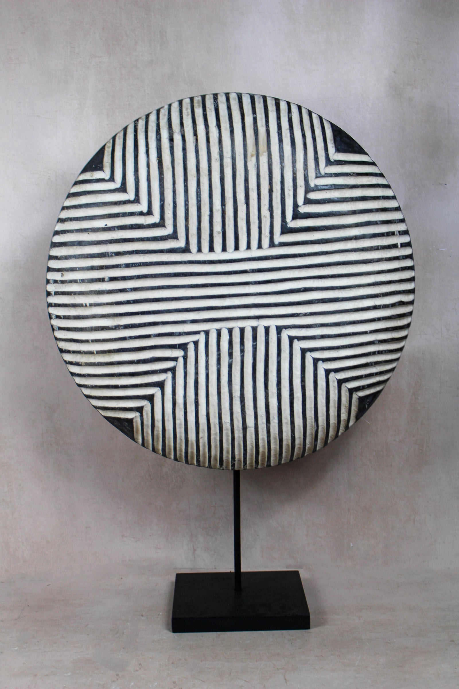 Large handmade Cameroon round shield with a bold geometric design, on a stand