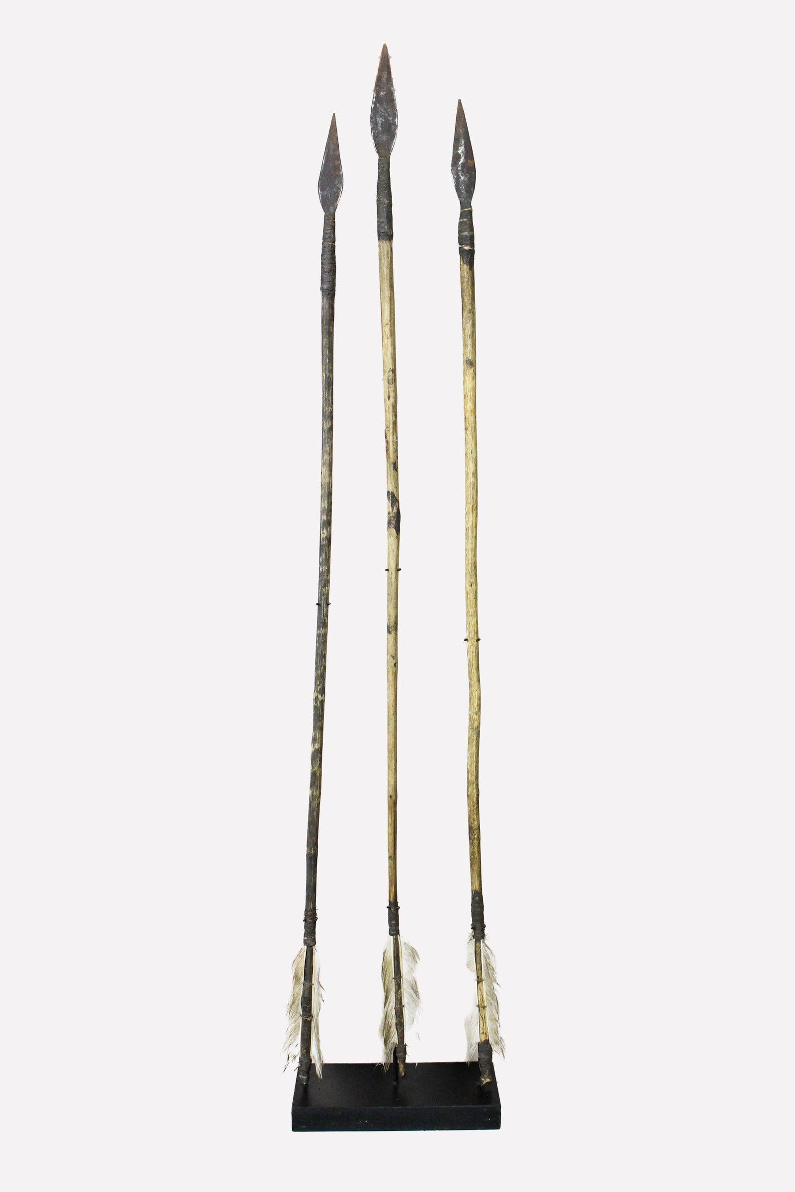 Set of three hand-forged vintage Lozi arrows from Zambia on a display stand