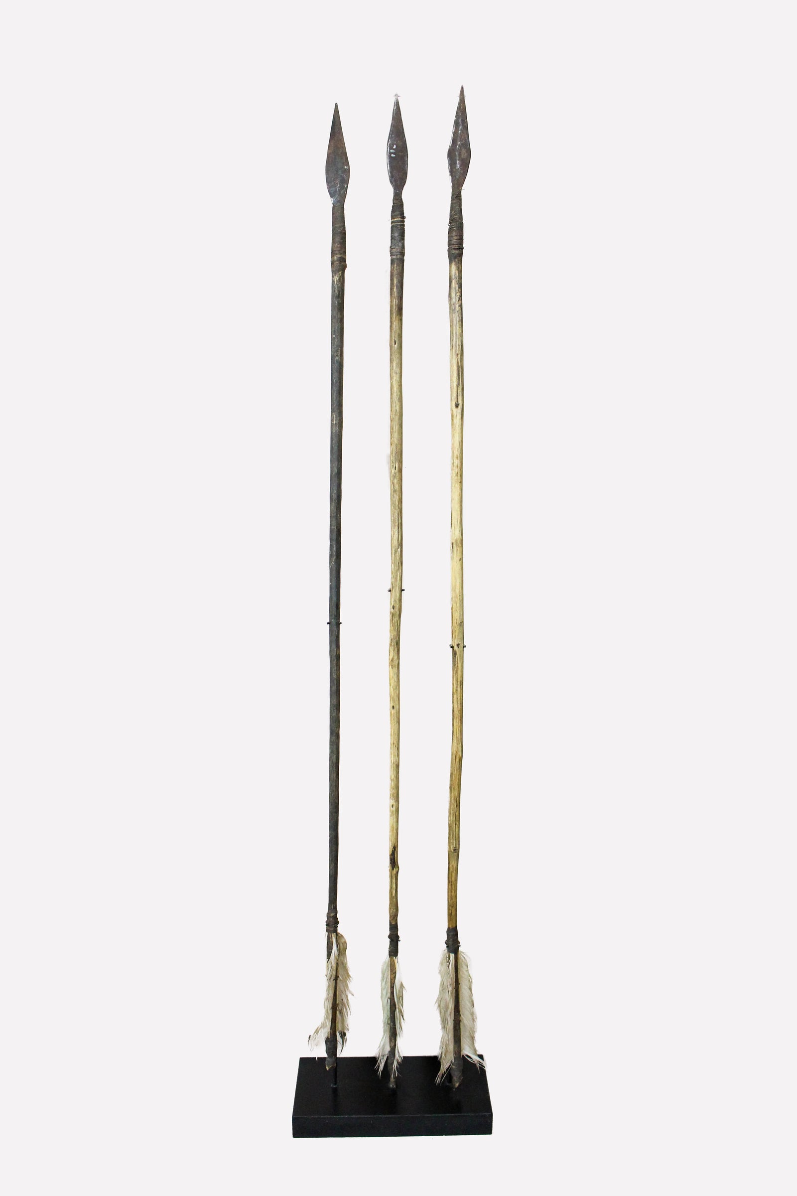 Set of three hand-forged vintage Lozi arrows from Zambia on a display stand