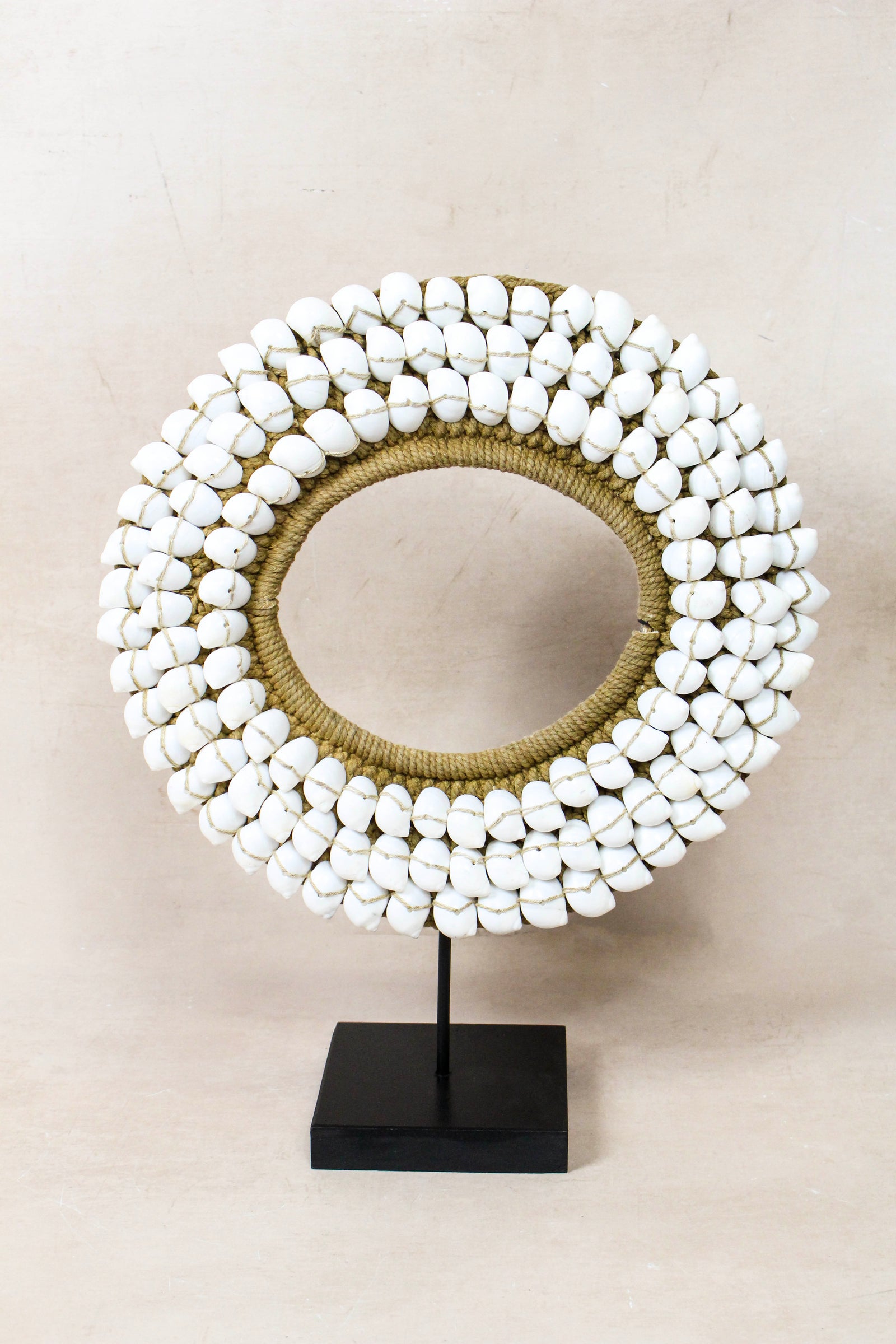Handmade Indonesian white shell necklace on a display stand