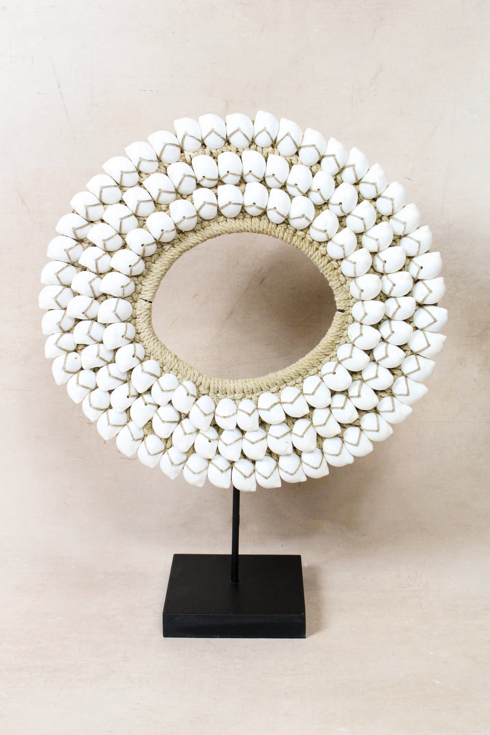 Handmade Indonesian white shell necklace on a display stand