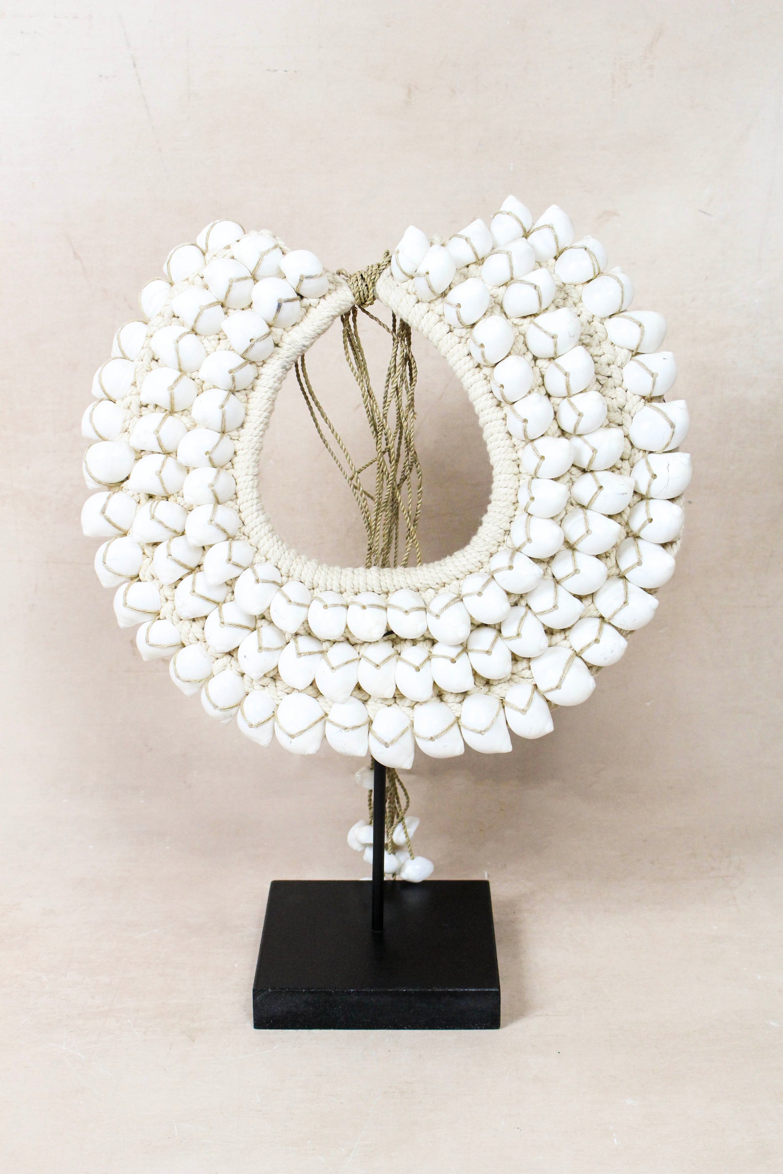 Handmade Indonesian white shell necklace on a display stand