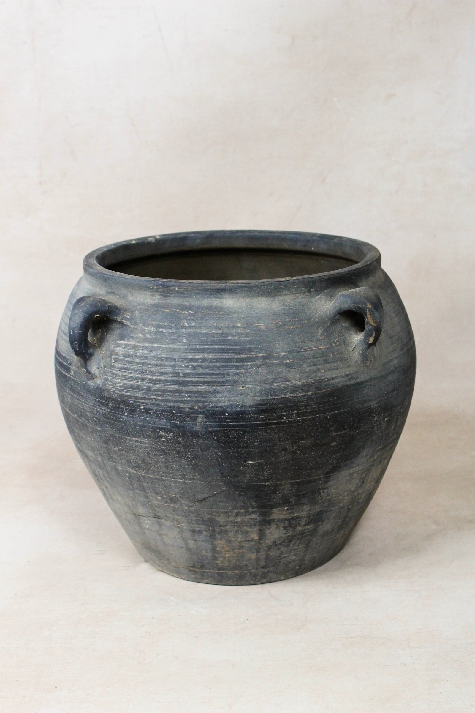 Vintage dark unglazed earthenware pot with decorated ear handles