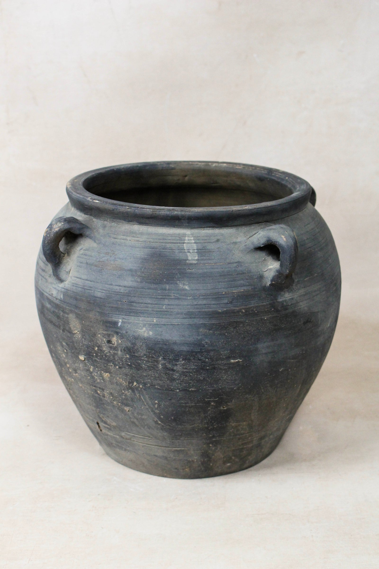 Vintage dark unglazed earthenware pot with decorated ear handles