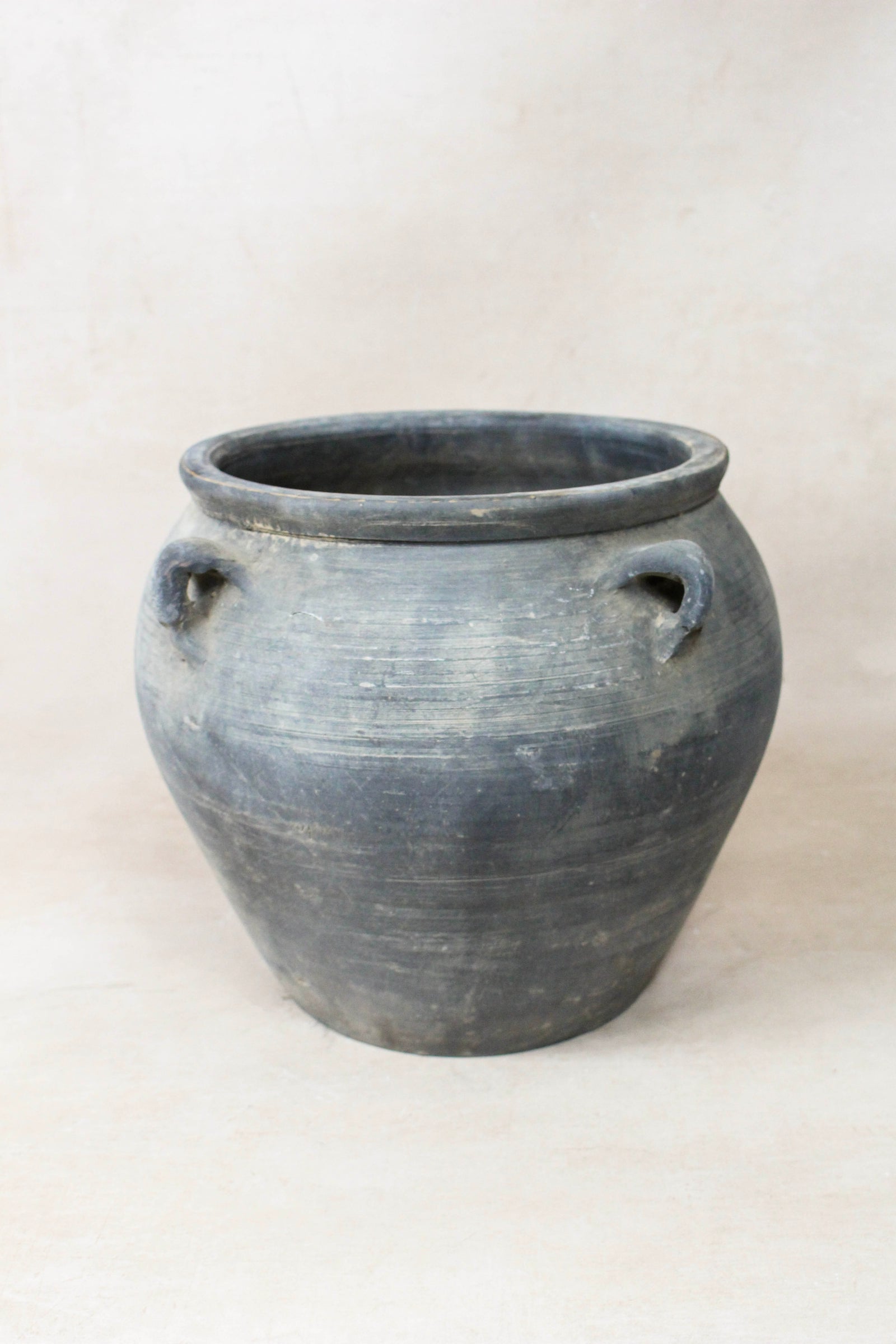 Vintage dark unglazed earthenware pot with decorated ear handles