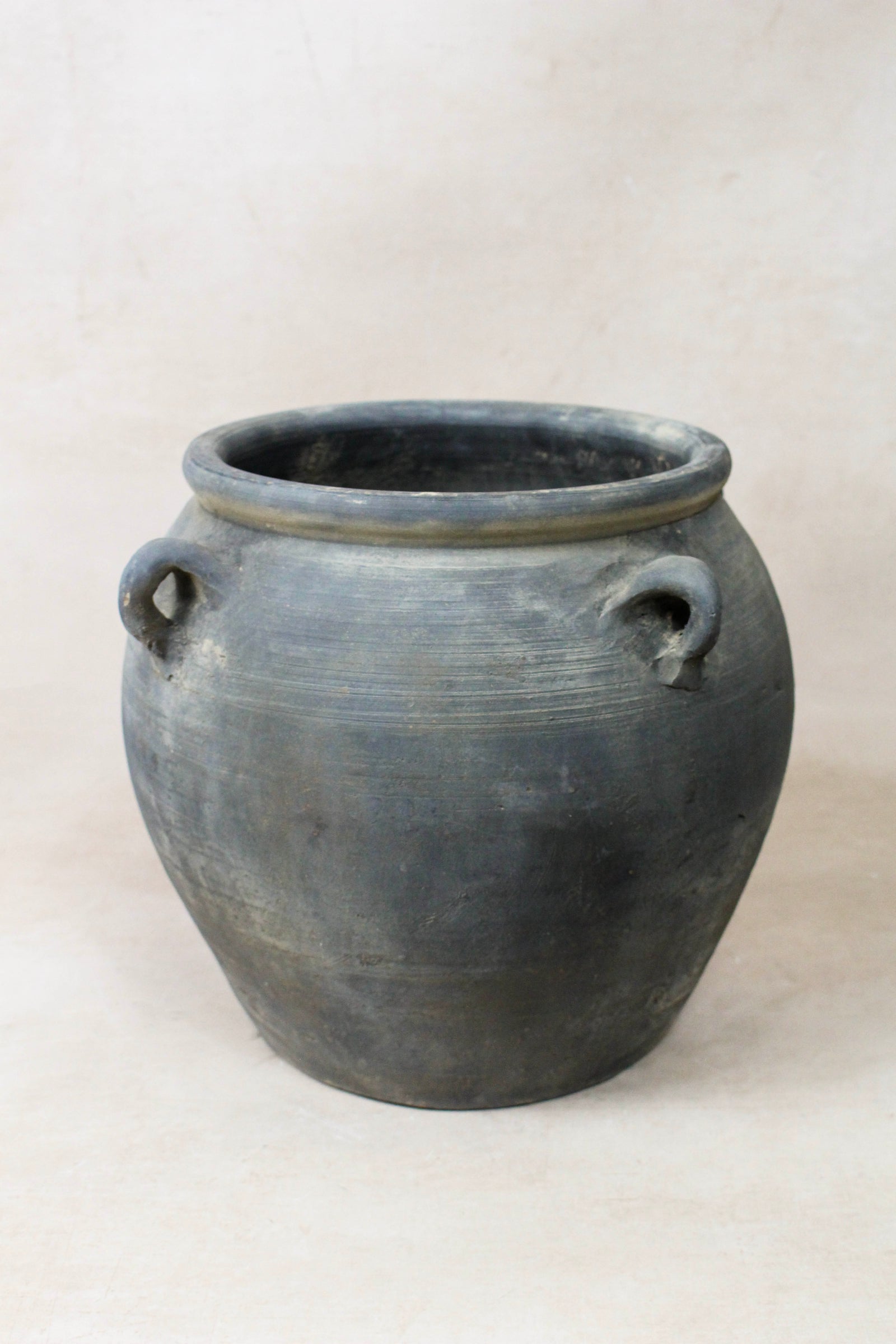 Vintage dark unglazed earthenware pot with decorated ear handles