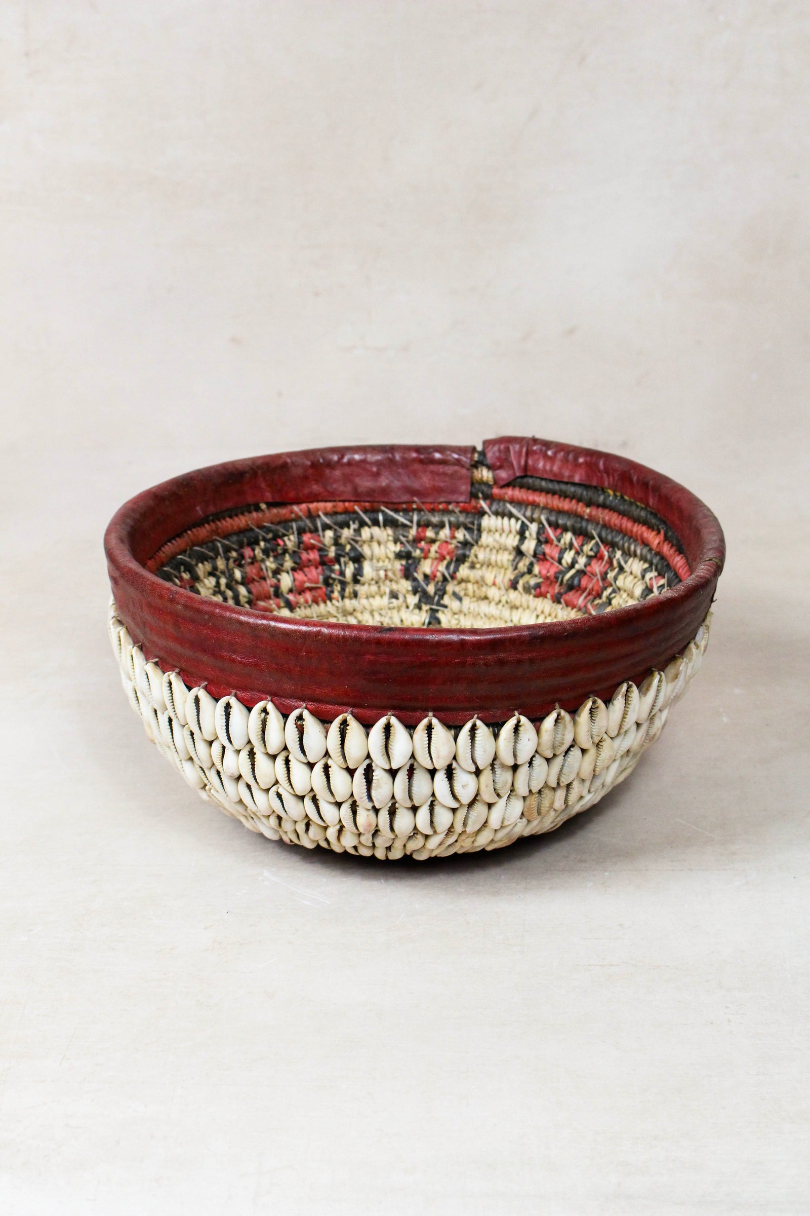Vintage Hausa cowrie shell bowl from Northern Nigeria, woven grass with leather rim