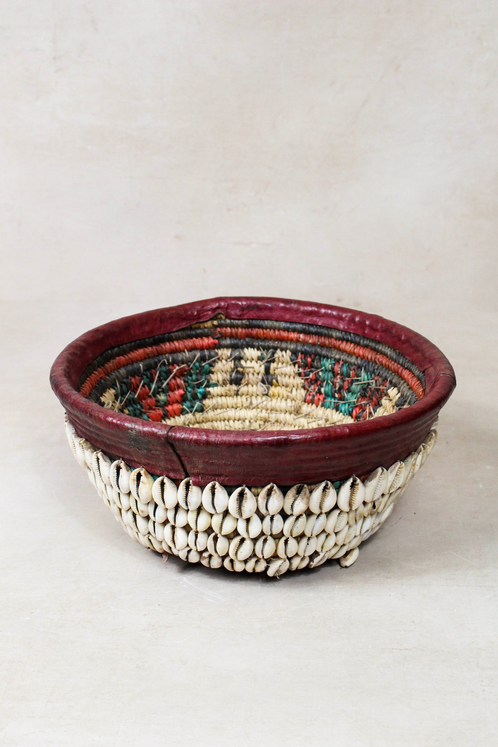 Vintage Hausa cowrie shell bowl from Northern Nigeria, woven grass with leather rim