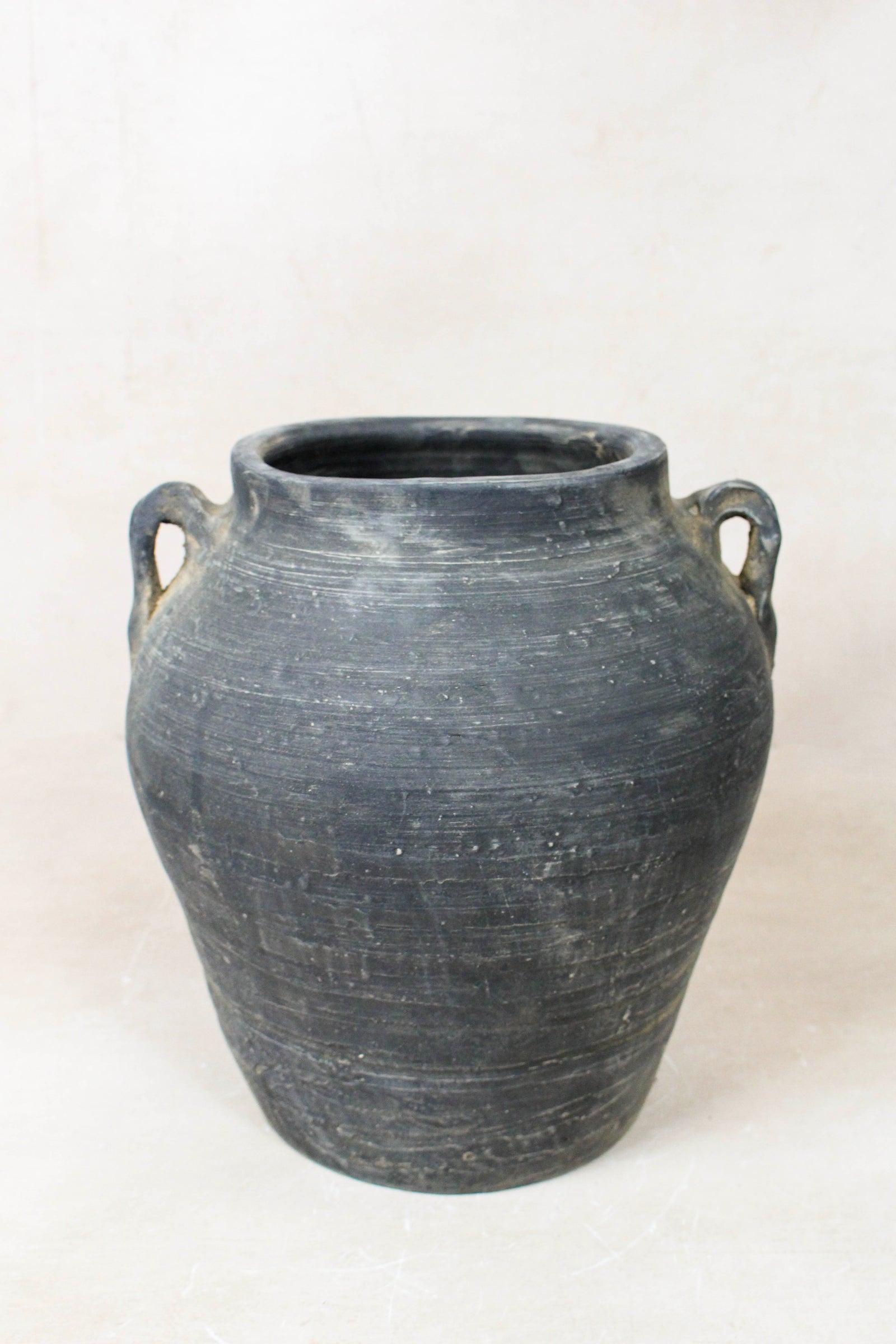 Vintage dark unglazed earthenware pot with decorated ear handles