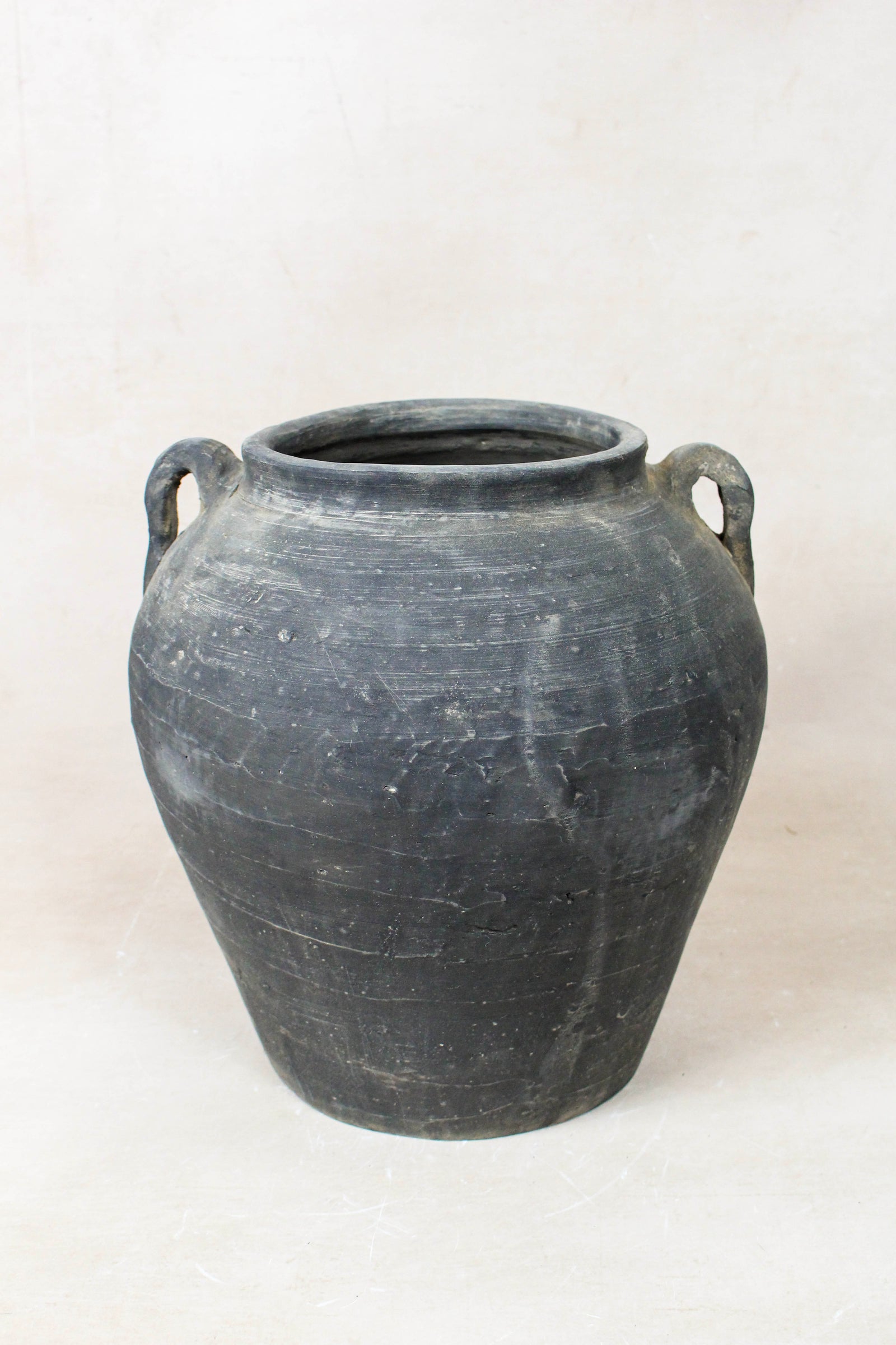Vintage dark unglazed earthenware pot with decorated ear handles