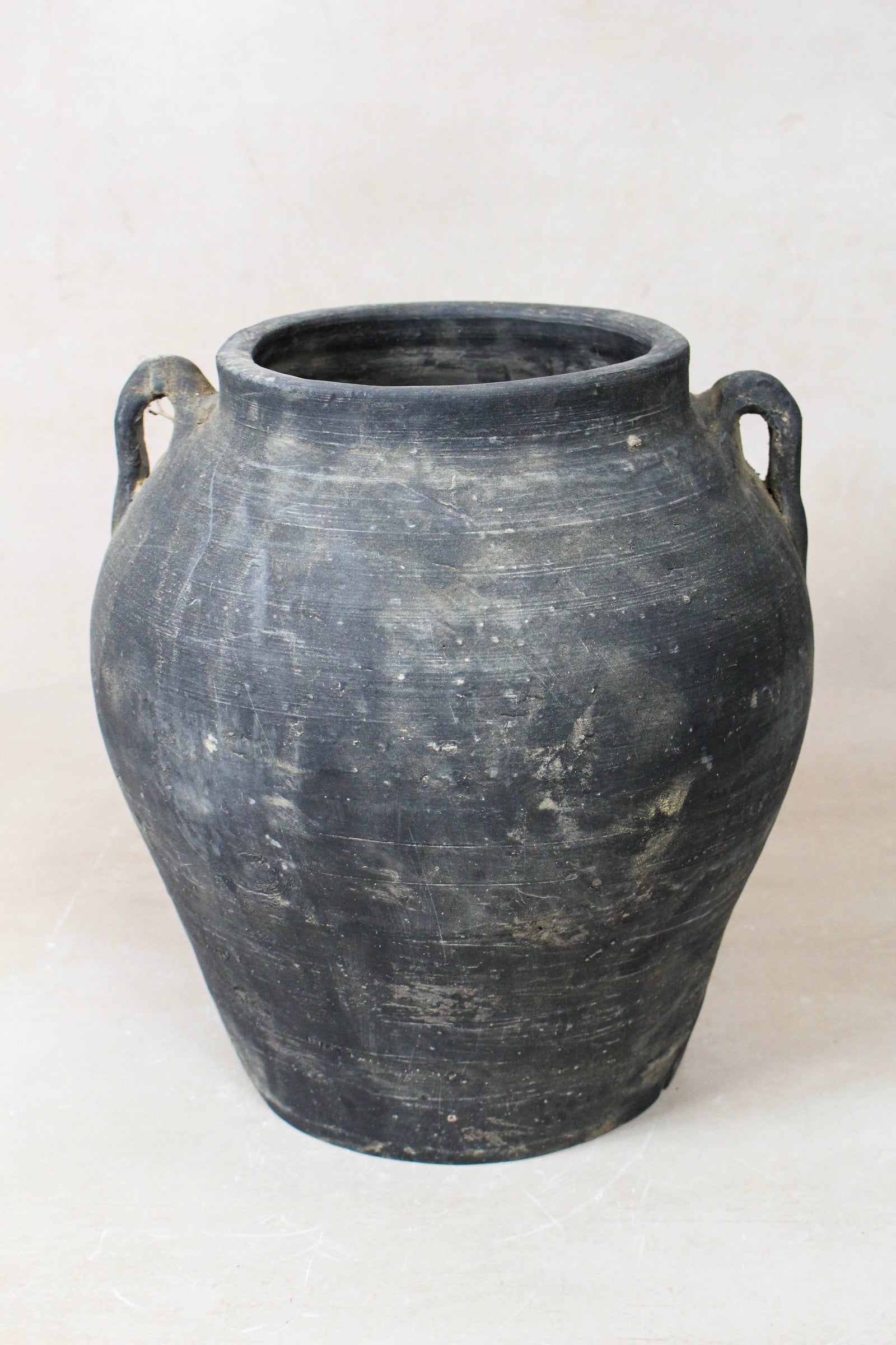 Vintage dark unglazed earthenware pot with decorated ear handles