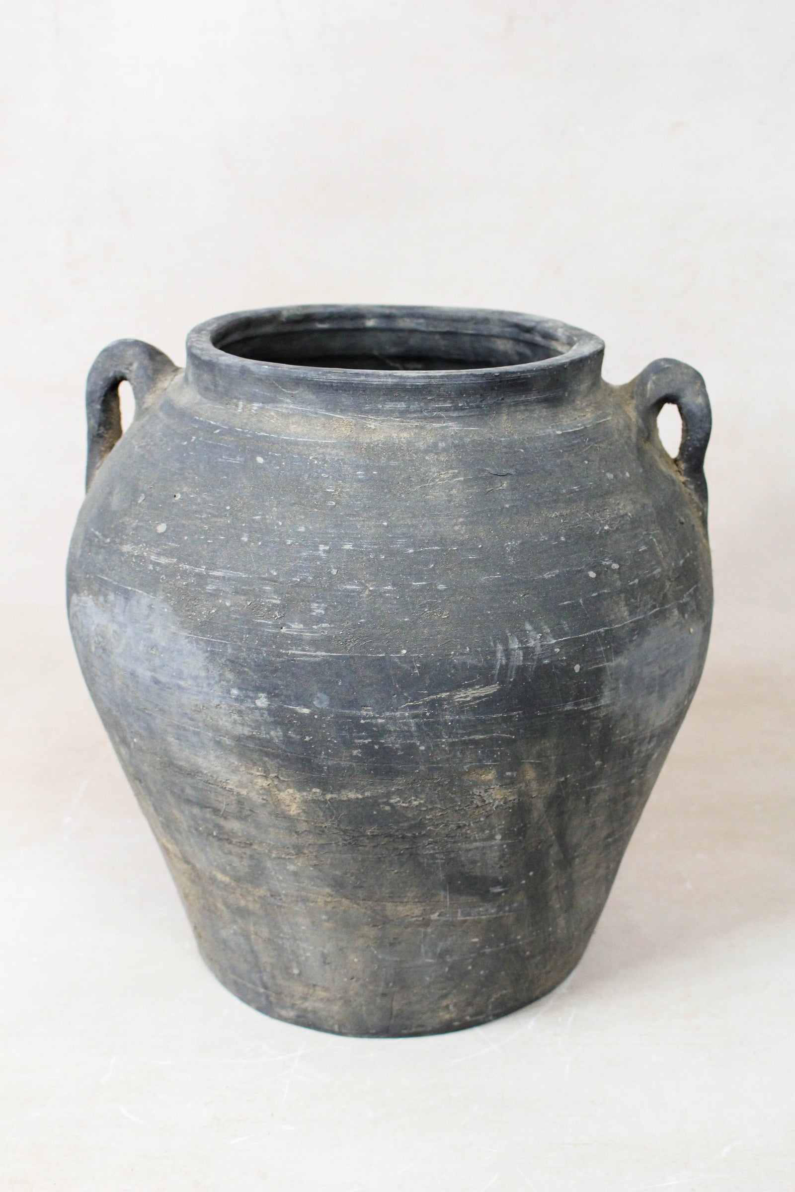 Vintage dark unglazed earthenware pot with decorated ear handles