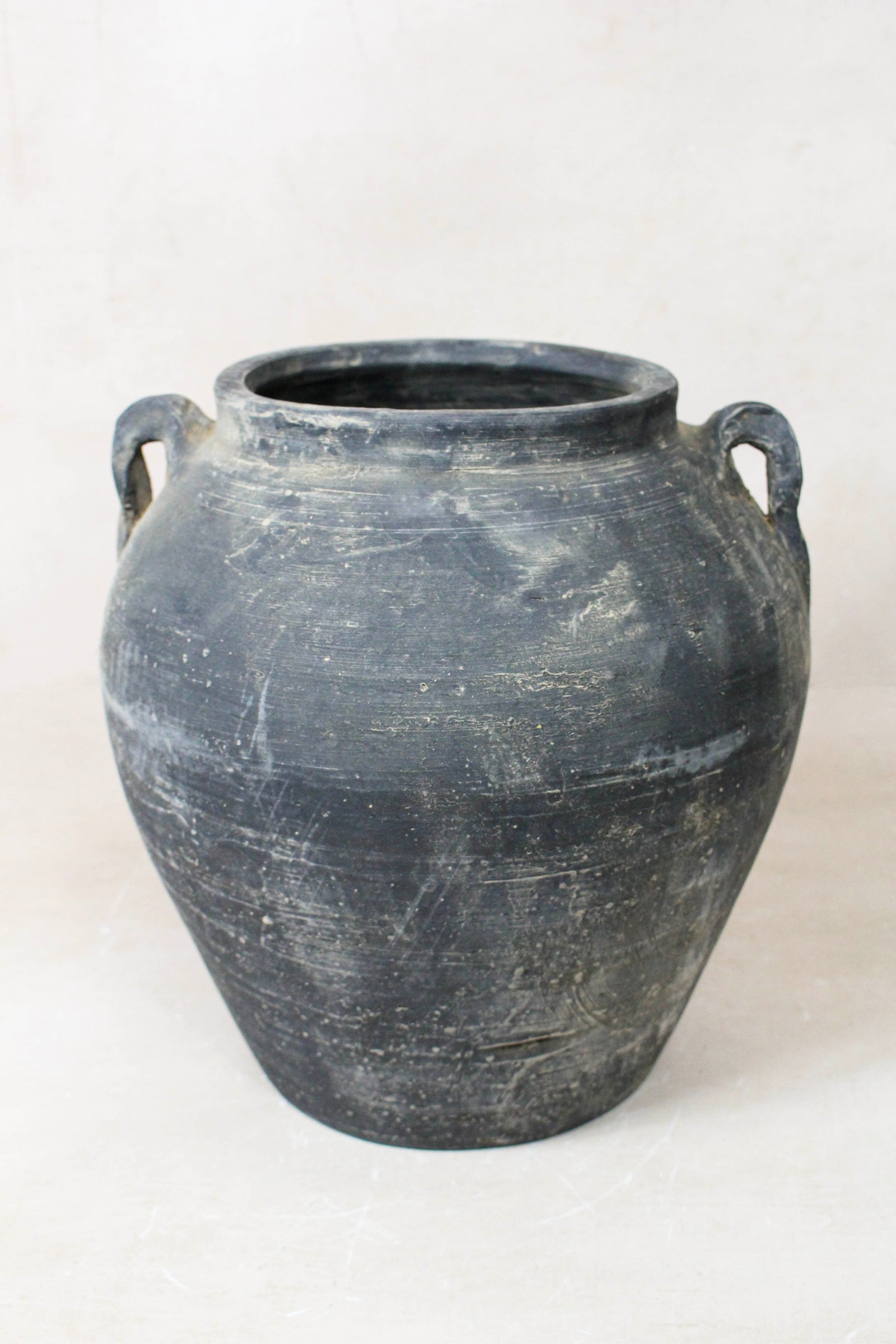 Vintage dark unglazed earthenware pot with decorated ear handles