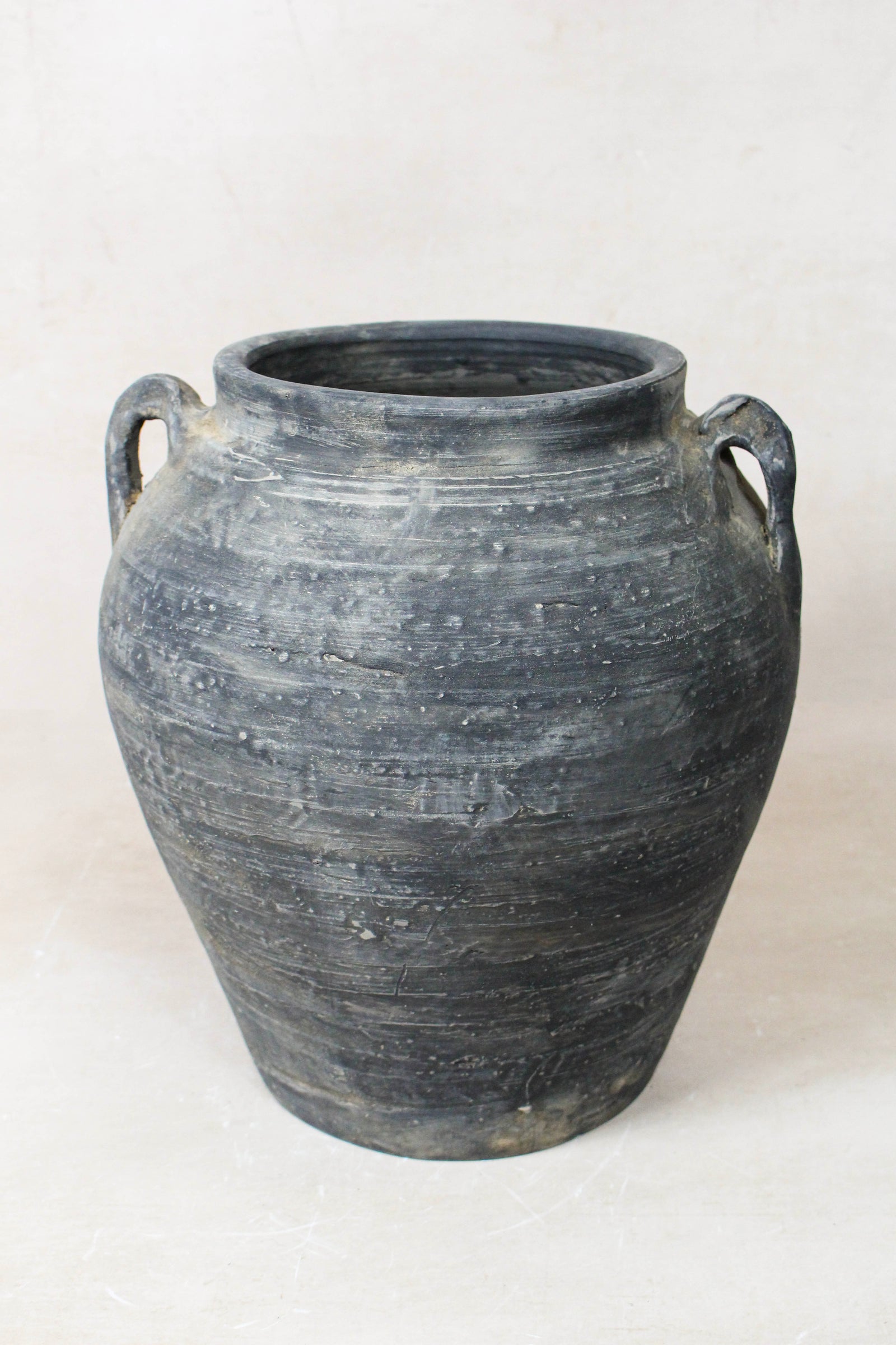 Vintage dark unglazed earthenware pot with decorated ear handles