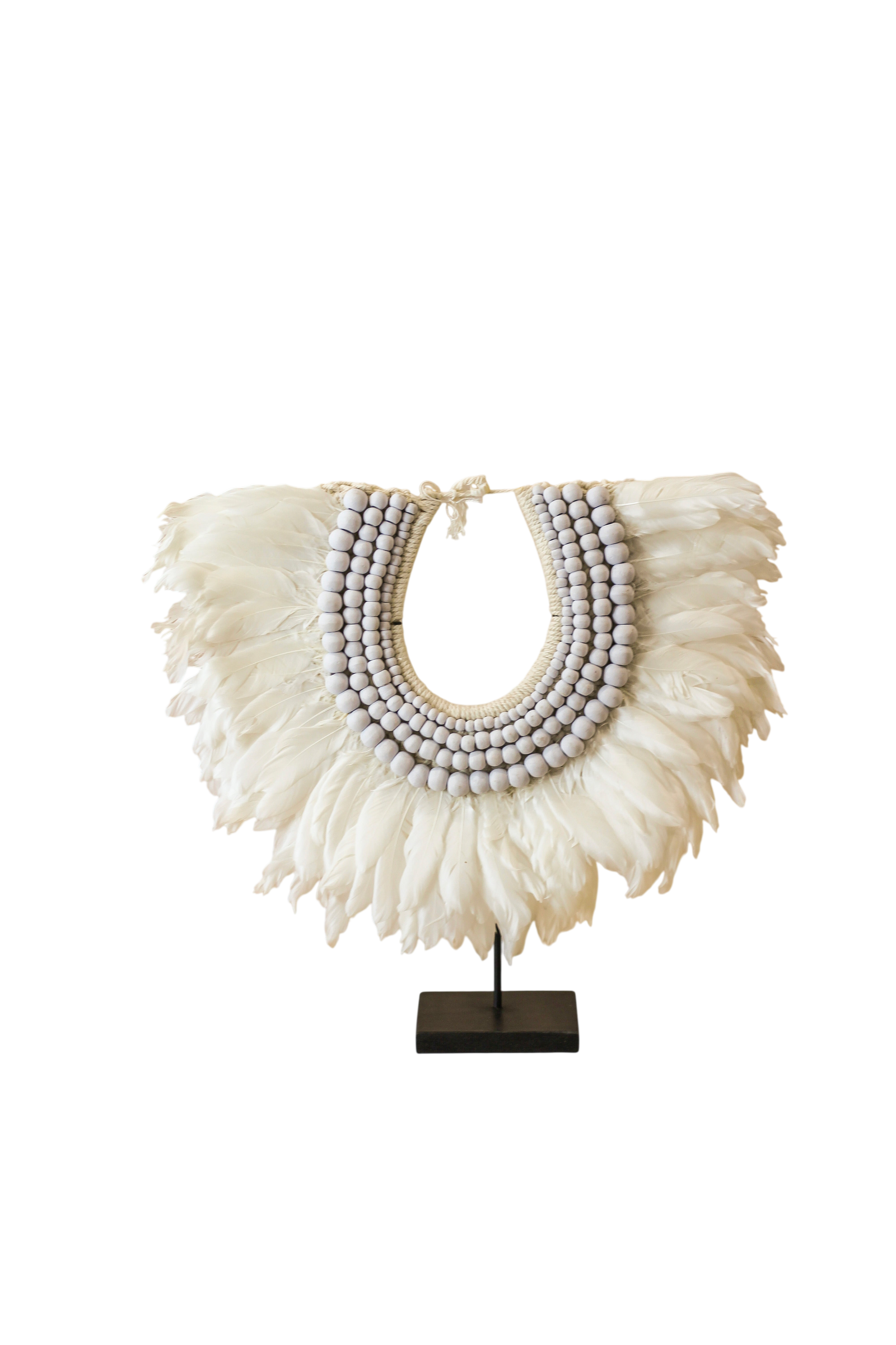 Handmade Indonesian feather and bead necklace on a display stand